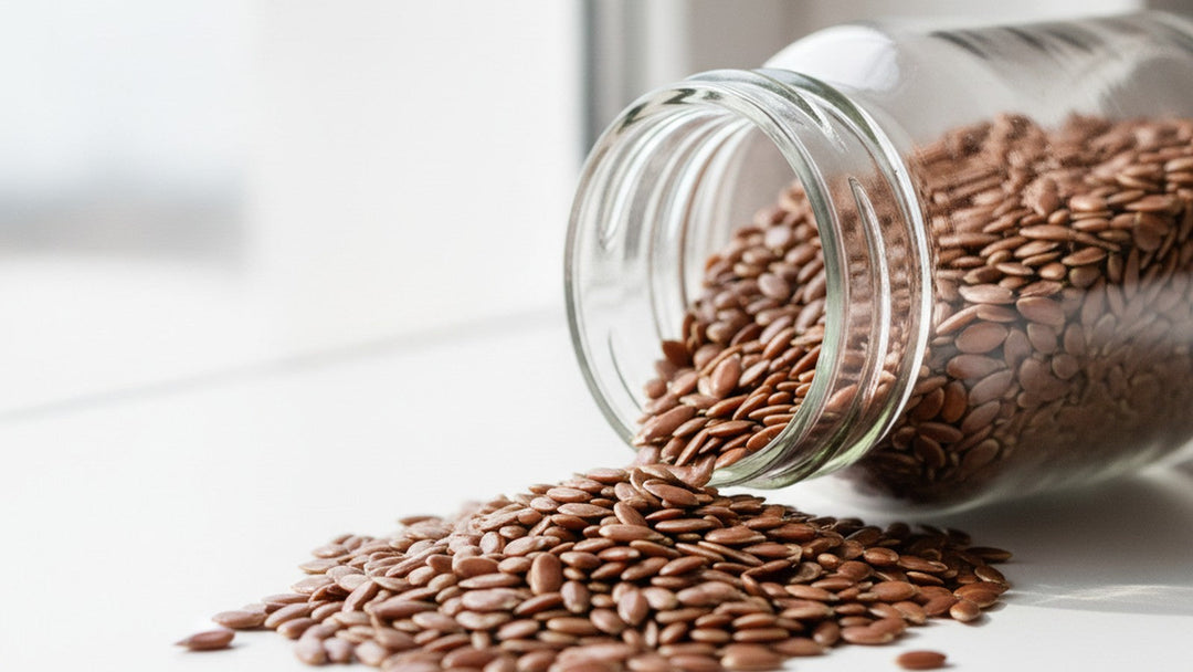 Flaxseeds spilling from glass bottle