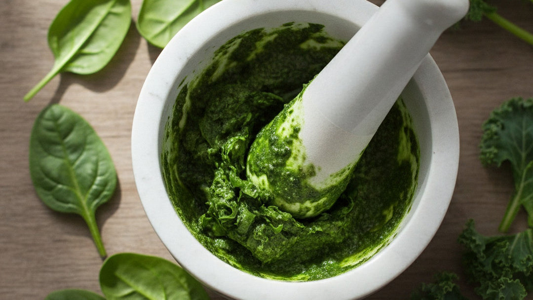 Mortar and pestle grinding fresh green leaves into chlorophyll paste