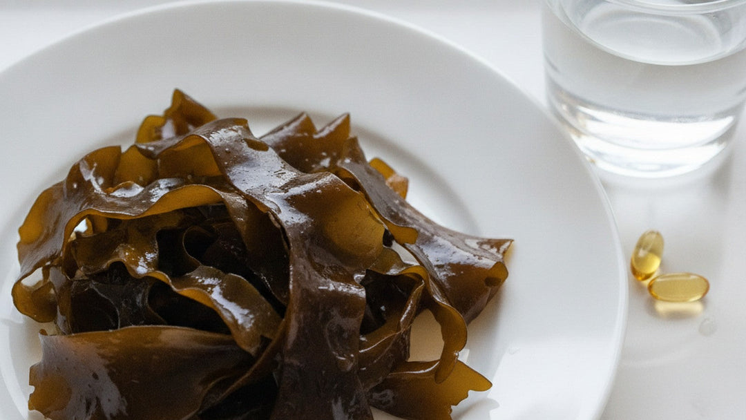Brown seaweed on white plate with supplement capsules