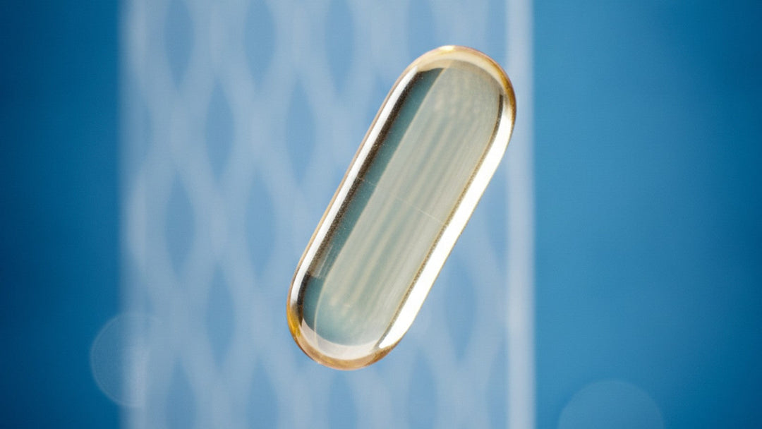 Clear supplement capsule floating against blue background with barrier texture
