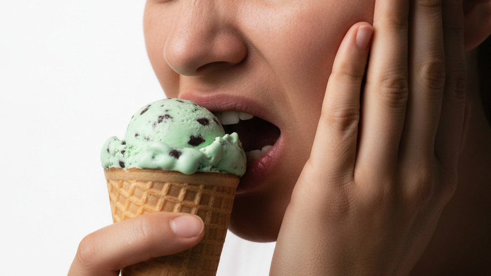 Person grimacing in pain while eating ice cream