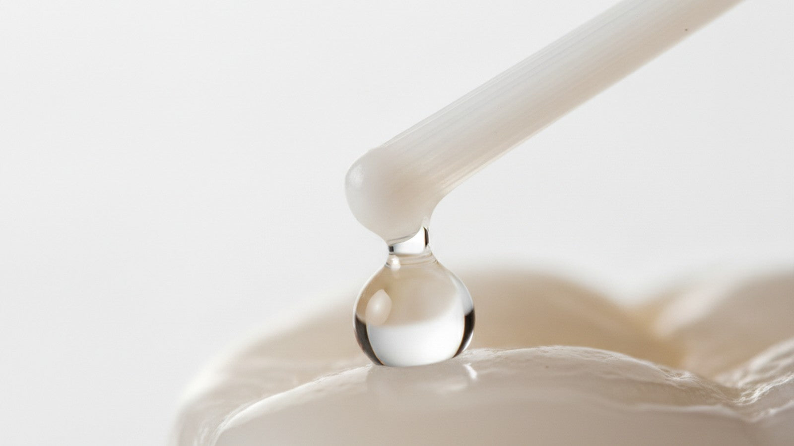 Toothbrush bristle above tooth enamel with water droplet