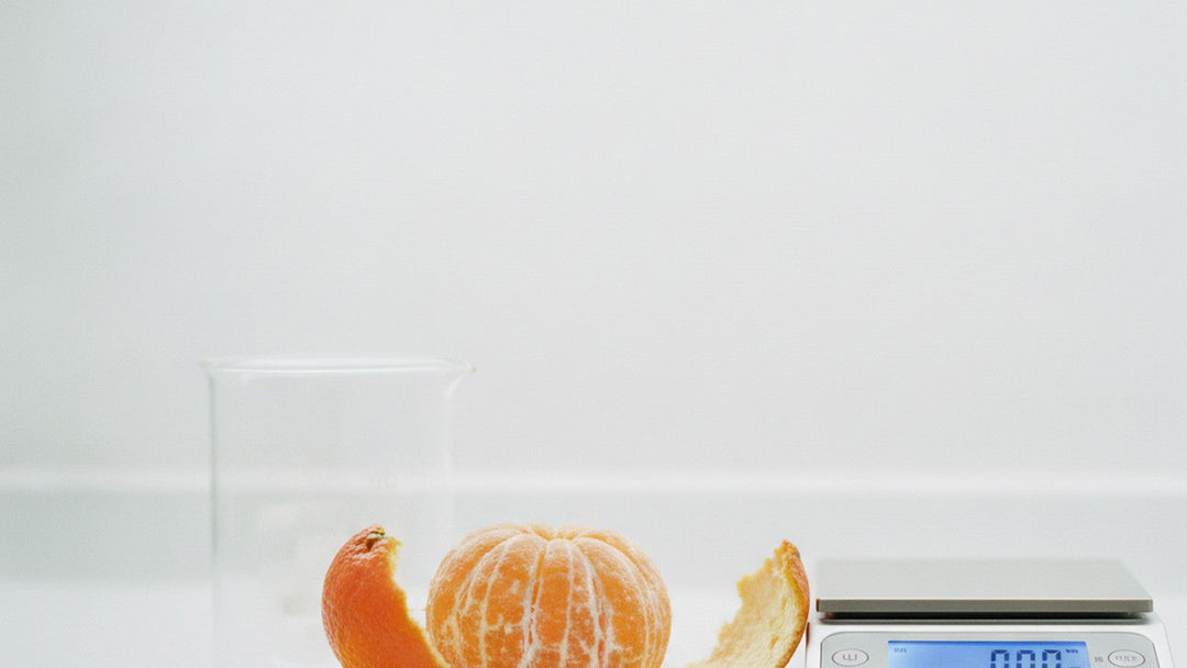 Peeled tangerine next to empty beaker on laboratory bench