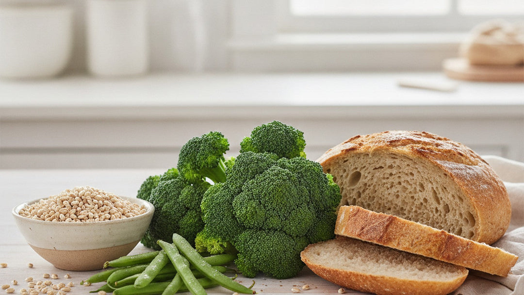 Fresh broccoli, whole-grain sourdough, green beans and a bowl of barley on a bright kitchen table