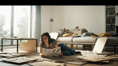 An animated GIF of a woman frustrated by complex furniture instructions. A magical English nanny floats down and gives her a single glowing green Allen key, and the furniture assembles itself perfectly, symbolizing women's health support.